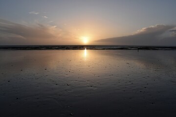 sunset over a low tide beach in Normandy 