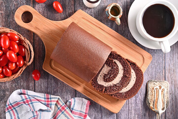 Chocolate roll cake on the wooden cutting board  