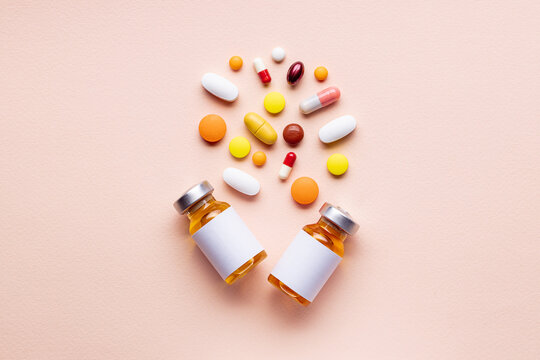 assorted medical supplies isolated on pink background. pills,tablets, capsules and vials composition. pharmacy concept. medicine conceptual. above view