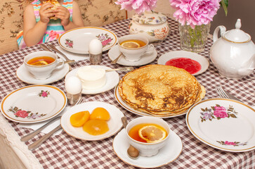 Traditional Russian or Ukrainian breakfast: homemade pancakes and tea with lemon. Traditional Russian or Belarusian cuisine. Maslenitsa. Stack of creps (aka blini).