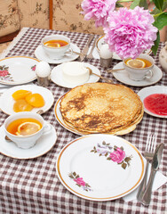 Traditional Russian or Ukrainian breakfast: homemade pancakes and tea with lemon. Traditional Russian or Belarusian cuisine. Maslenitsa. Stack of creps (aka blini).