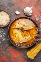 top view bowl of chicken soup garlic bowl of rice dry spaghetti on dark red background