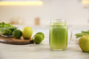 Tasty fresh juice in mason jar on table indoors. Space for text