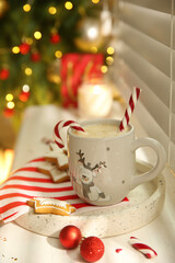 Composition with cup of hot drink on windowsill
