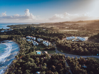 Aerial drone view of the paradise beach with tropical residence, palm trees and blue water of Atlantic ocean at sunrise, Las Terrenas, Samana, Dominican Republic