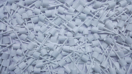 Parts of white cosmetic plastic products  on the production line in industrial factory.Used to assemble bottle caps.

