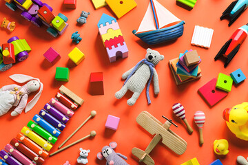 Different toys on orange background, flat lay
