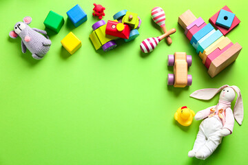 Different toys on green background, flat lay. Space for text