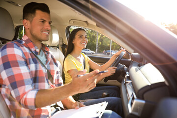 Young woman in car with instructor. Driving school