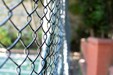 Closeup of metal rabitz grid. Horizontal rabitz net background. Mesh texture against green meadow.