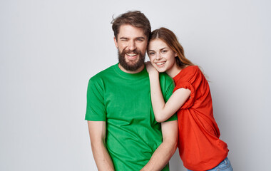 Obraz premium young couple in multicolored t-shirts emotions studio friendship