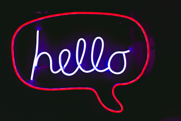 Neon night light greeting word sign text "Hello" on black background. © Quality Stock Arts