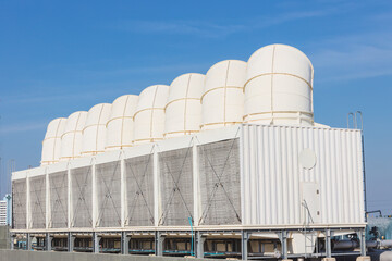 Fototapeta premium Air cooling tower for HVAC chilling units at building rooftop outdoor blue sky.