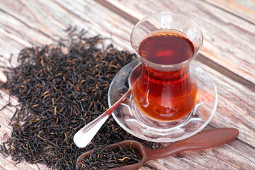 A cup of Turkish black tea and tea leaves
