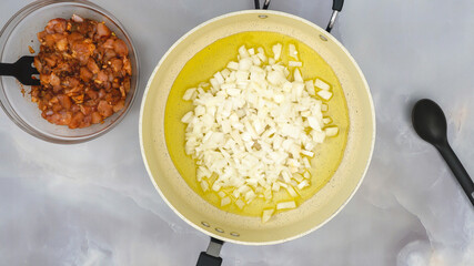 Olive oil and chopped onion close up on frying pan. Sour cream chicken paprika recipe, step by step cooking process
