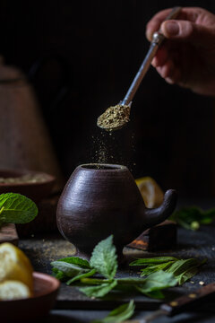 Latin American hot drink yerba mate in clay cup, herbs amd lemon
