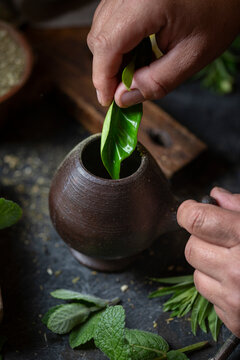Latin American hot drink yerba mate in clay cup, herbs amd lemon