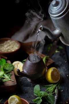 Latin American hot drink yerba mate in clay cup, herbs amd lemon