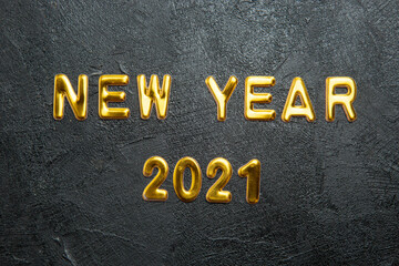 Top view of greeting golden text New Year and on dark background