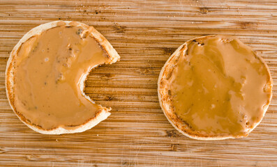 plant-based food, English muffins with smooth peanut butter topping on cutting board