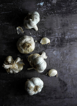 Garlic heads and cloves over dark background