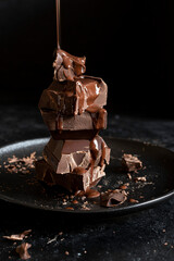 Stack of chocolate cubes on black background