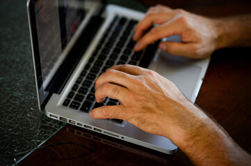 Female hands typing on laptop keyboard at the office, at home