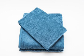 白背景に置いて撮影した青いバスタオルとフェイスタオル