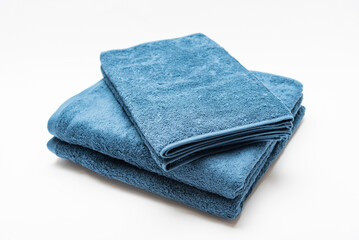 白背景に置いて撮影した青いバスタオルとフェイスタオル