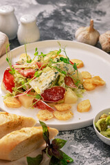 Organic salad. Guacamole, green olives, raw smoked sausage, baguette, ice salad and blue cheese with micro green peas. Dinner in Italian style. Vertical shot