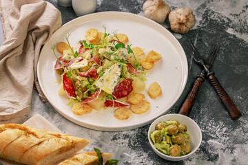 Organic salad. Guacamole, green olives, raw smoked sausage, baguette, ice salad and blue cheese with micro green peas. Dinner in Italian style.