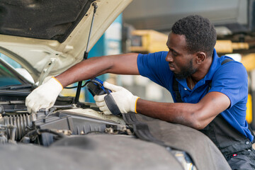 Fototapeta na wymiar African-American mechanic working in car service center