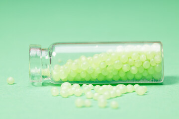 glass bottle with cork with green granules on a green background