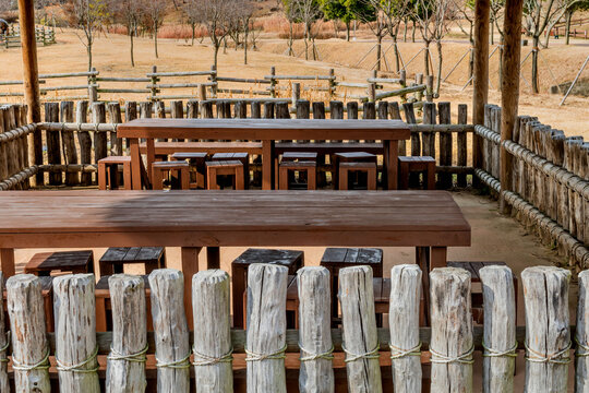 Closeup of covered wooden picnic tables © aminkorea