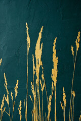 Green textured wall with a picture of grains of gold paint. Interior wall decoration.