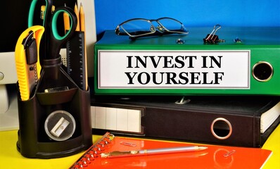 Invest in yourself. Lettering of the text in the folder on the background of stationery. Placement...