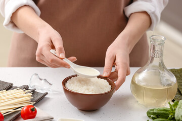 Woman preparing sauce with rice vinegar in kitchen