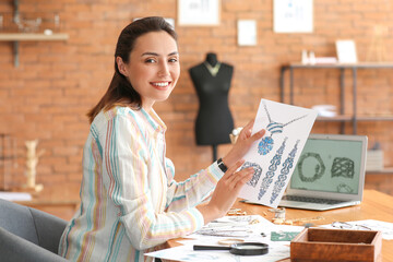 Female jewelry designer with sketches working in office
