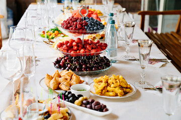 table served with light summer snacks-fruits, vegetables, berries. 