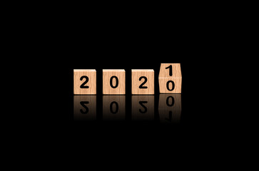 2020 flipped to 2021 made by blocks wood in luxury black background, The Change Coming Concept.