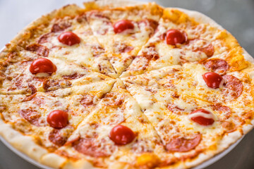 pepperoni pizza with cheese and tomatoes. ordering food at home.