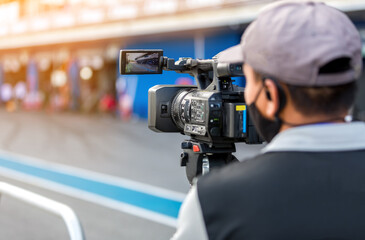 Video camera operator working with his equipment. video cinema production. Covering an event with a video camera. Professional video man hand holding camera operator camcorder working.