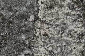 Monochrome stone wall as a background with rough and cracked surface, space for text