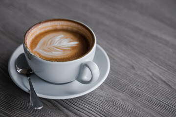 Hot coffee in white cup on wood background. drink with caffeine concept.