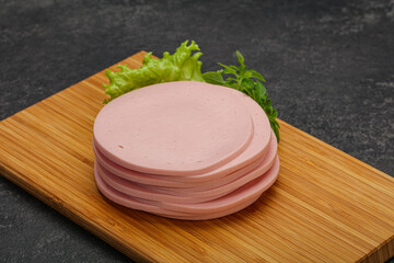 Sliced pork natural sausages over board