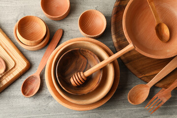 Different wooden dishes on gray table, top view