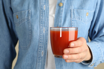 Woman hold glass of tomato juice, close up