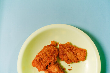 fried tempeh on yellow plate with blue background