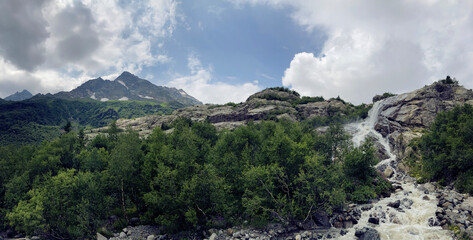 Waterfall on summer day in nature. Rapid water stream falling from rocks against blue sky on sunny...