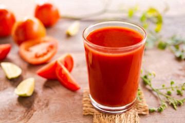 Tomato juice in glass with row tomato on wood background. fresh organic vegetables. healthy juice drinks concept.